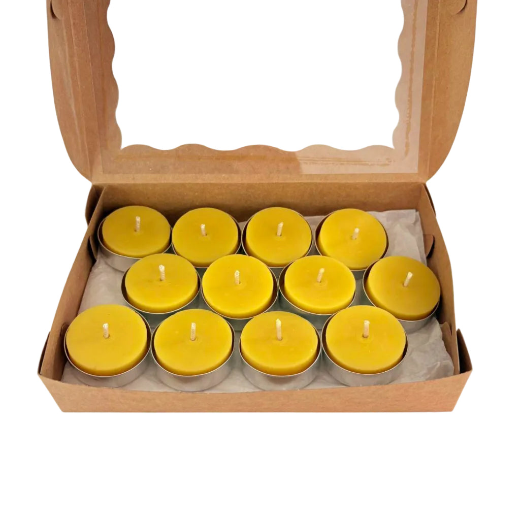 An open brown cardboard gift box with a clear window lid, containing ten small yellow tea light candles arranged in two rows on white tissue paper.