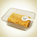 A clear plastic container holding a rectangular piece of honeycomb with visible honey pools in the cells, sealed with a white paper label that reads 'Winter Honey' and 'Winter Farm'.