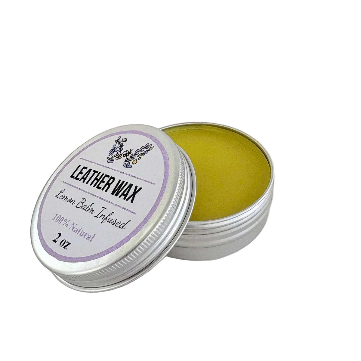 An open silver metal tin of lemon balm infused leather wax, showing the yellow-green balm inside, with the lid leaning against it on a light gray background.