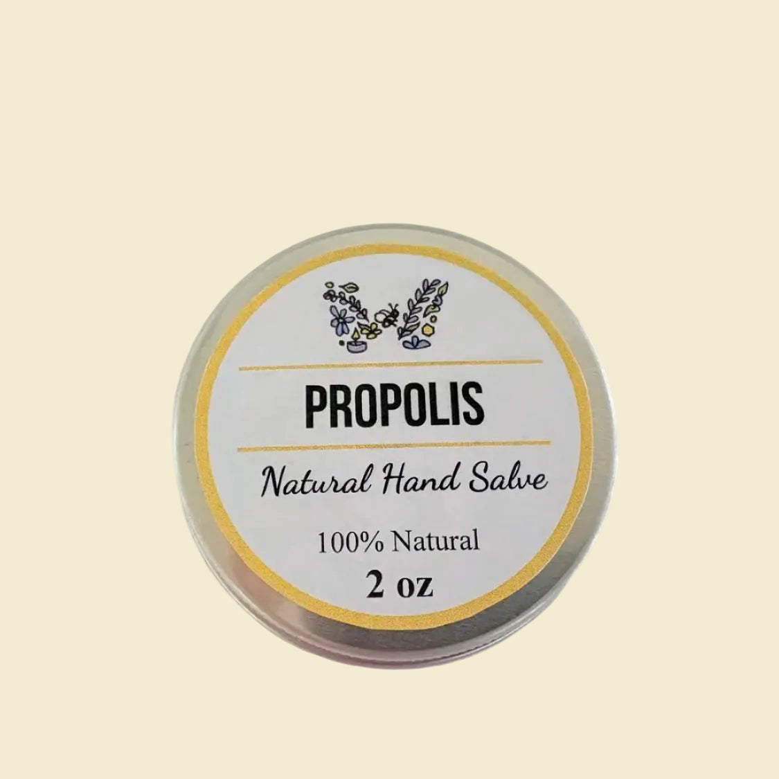 A round metal tin of Propolis Natural Hand Salve on a plain off-white background. The label features a yellow border, a butterfly design made of small flowers, and black text reading 'PROPOLIS', 'Natural Hand Salve', '100% Natural', and '2 oz'.